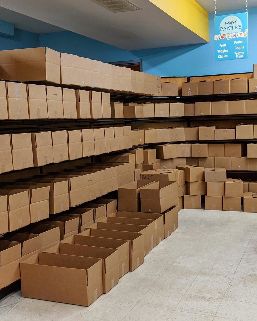Rows of cardboard boxes line shelves at Just Food food pantry